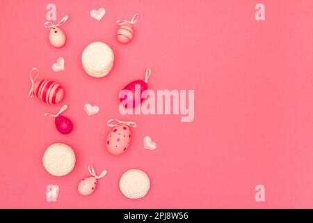 Easter eggs, small hearts and big marshmallows on pink background provide ample space for copying Stock Photo