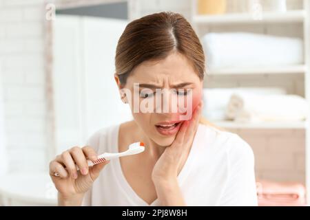 Young woman suffering from acute toothache indoors Stock Photo