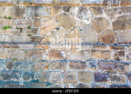 Old stone walll made of rocks and cement Stock Photo
