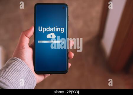 Woman updating software on smartphone. System engineer and programming. Software apps developer. Stock Photo