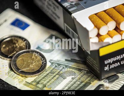 HAARLEM - A pack of cigarettes together with two two euro coins and a note of 5. The excise duty on tobacco will increase by 1.22 euros on Saturday 1 April. For a pack of twenty cigarettes, an average of 9 euros must be paid. In a year's time, another 1.22 euros will be added and a pack of cigarettes will cost an average of 10 euros. ANP REMKO DE WAAL netherlands out - belgium out Credit: ANP/Alamy Live News Stock Photo