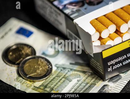 HAARLEM - A pack of cigarettes together with two two euro coins and a note of 5. The excise duty on tobacco will increase by 1.22 euros on Saturday 1 April. For a pack of twenty cigarettes, an average of 9 euros must be paid. In a year's time, another 1.22 euros will be added and a pack of cigarettes will cost an average of 10 euros. ANP REMKO DE WAAL netherlands out - belgium out Credit: ANP/Alamy Live News Stock Photo