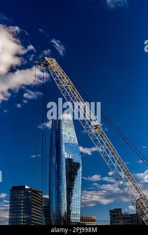 One Blackfriars and giant crane in the foreground against a deep blue sky.Room for editorial copy on portrait shape image.Construction concept. Stock Photo