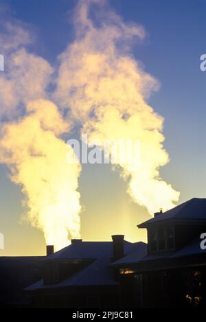 WINTER HEATING PLUMS OF SMOKE FROM HOME RESIDENTIAL CHIMNEYS Stock Photo