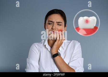 Young woman suffering from acute toothache on grey background Stock Photo