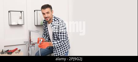 Plumber installing new water tap in bathroom, space for text. Banner design Stock Photo
