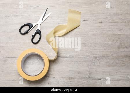 Roll of adhesive tape and scissors on light background, top view. Space for  text Stock Photo - Alamy