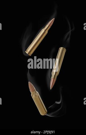 Bullets with smoke falling on black background Stock Photo