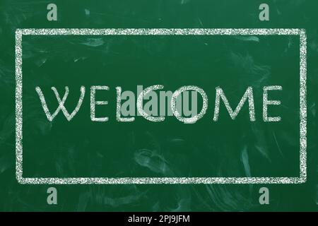 Word WELCOME written on green chalkboard, top view Stock Photo