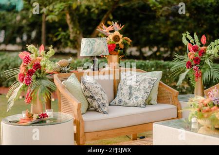 An outdoor setting featuring a table adorned with lamps and vases filled with beautiful colorful flowers Stock Photo