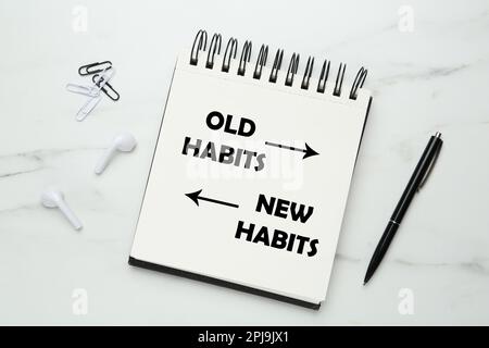 Notebook with two opposite directions to Old and New Habits on white marble background, flat lay Stock Photo