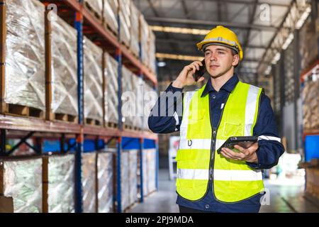 engineer worker using smartphone phone calling people in factory store warehouse Stock Photo