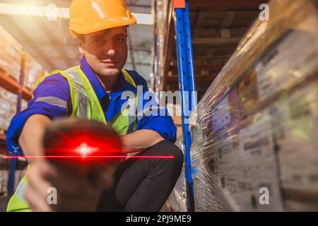 Inventory staff worker with handheld red laser barcode scanner label scan goods management technology device Stock Photo