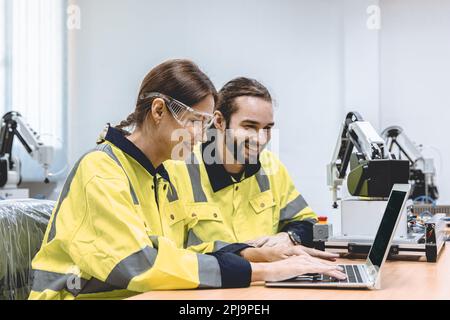 Engineer team software developer happy working together typing program source code for robot control Stock Photo