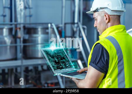 Smart engineer worker using software on laptop to monitor check factory boiler pipe valve control system Stock Photo