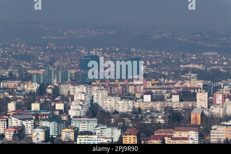 Cityscape of Banja Luka during sunny day, distant hill fade in hazy polluted air Stock Photo