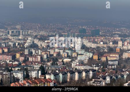 Cityscape of Banja Luka during sunny day, distant hill fade in hazy polluted air Stock Photo