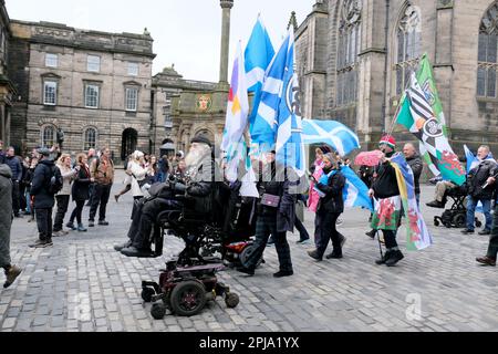 Edinburgh, Scotland, UK. 1st April 2023. A March for Scottish independence organised by Yes2Independence, commencing at Johnston Terrace in view of Edinburgh castle then marching down the Royal Mile and finishing at the Scottish parliament at Holyrood.  Marching down the Royal Mile. Credit: Craig Brown/Alamy Live News Stock Photo