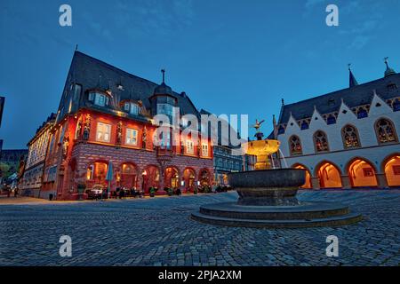 Market square at night, Guild House Kaiserworth left, Rathaus town hall right and fountain in Marktplatz Old Town UNESCO world heritage site, Goslar. Stock Photo