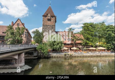 Medieval Schuldturm tower part of the city wall from 1323 by Pegnitz river and Heubrucke bridge. Old Town Altstadt in Vordere Insel Schutt. Nuremberg. Stock Photo