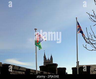 Welsh flag and union flag side by side flying in the breeze March 2023. Spring Stock Photo