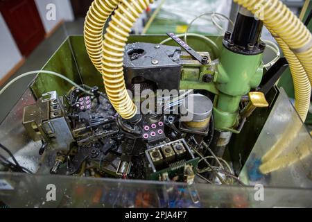 Textile industry with knitting machines in factory. Textile industry with a loom on the production of kapron tights. Stock Photo