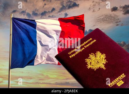 A French passport rests against the backdrop of the blue, white, and red colors of the French flag. Stock Photo