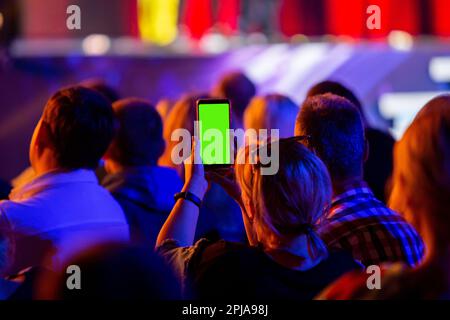 Filming a concert with his smartphone Stock Photo