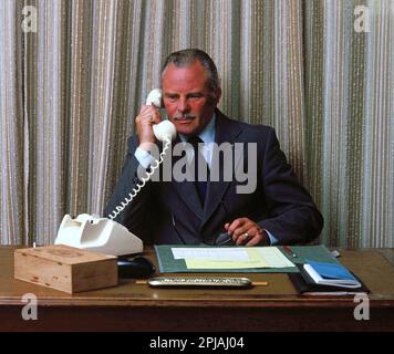 Business. Managing Director at desk using vintage telephone. Stock Photo