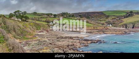 Colourful panoramic landscape of Talland Bay, Cornwall looking from West to East taking in the beautiful rock structure protecting this beautiful cove. Stock Photo