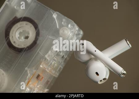 old music cassette and wireless headphones on an isolated background Stock Photo