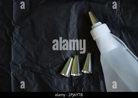 pastry bag and nozzles on a black Stock Photo