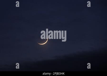 Young moon in the initial phase on a dark night sky Stock Photo