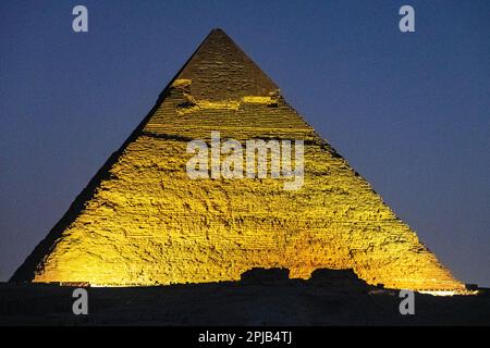 The Pyramids of Giza lit up with lights for the light and sound show at night in Egypt Stock Photo