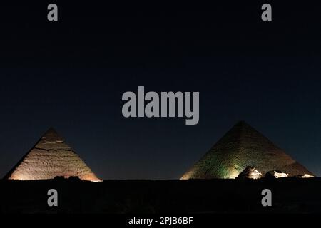 The Pyramids of Giza lit up with lights for the light and sound show at night in Egypt Stock Photo