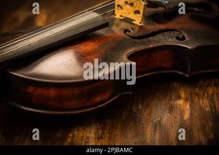 Detail of old violin in vintage style on wood background Stock Photo