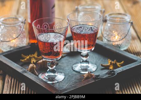 Two vintage glasses of red wine with bottle and lantern on wooden background Stock Photo