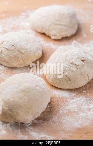 Freshly prepared yeast dough for pizza or bread on wooden background. Home cooking concept Stock Photo