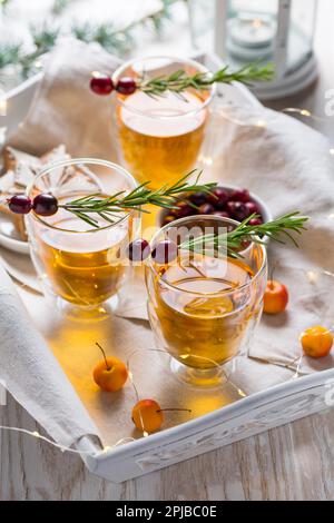 Christmas apple cider cocktail with cranberries, rosemary and gingerbread cookies. Mulled apple wine for Christmas Stock Photo