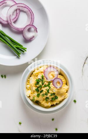 Egg spread with onion and chives on marble background Stock Photo