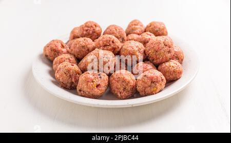 Raw meatballs on plate, ready for cooking or baking on white background Stock Photo