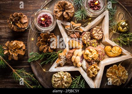 Variation of Christmas cookies and gingerbread with ornaments on wooden background Stock Photo