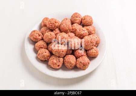 Raw meatballs on plate, ready for cooking or baking on white background Stock Photo