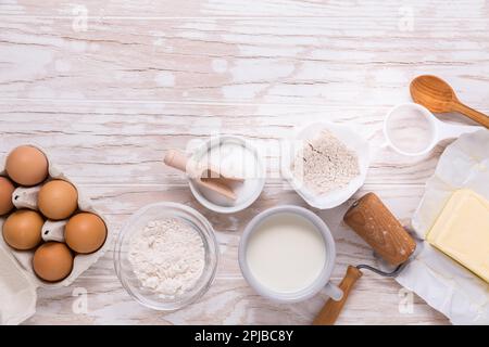 Assorted baking ingredients and kitchen utensils for cooking and baking on wooden background Stock Photo