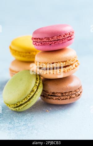 Assorted delicious French macarons on blue background Stock Photo