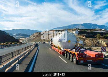 Truck transporting a large tank, on a special trailer for this type of transport. Stock Photo