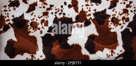 Texture of faux leopard fur with brown spots. Background of artificial material for sewing. Stock Photo