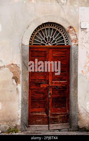 Iron filagree fan light over old wood door in Como, Italy. Stock Photo