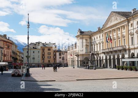 The main square in Aosta, Piazza Emile Chanoux with the Town Hall right and snow-capped mountains behind. Aosta Valley Italy Stock Photo