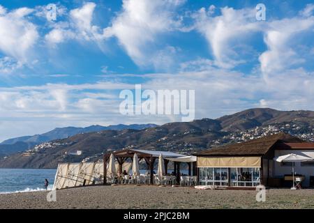 Salobreña, Spain; January-11, 2023: View of a typical chiringuito on a beach on the coast of Granada (Spain) with people eating by the sea Stock Photo